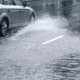 Car driving on huge puddle during a downpour