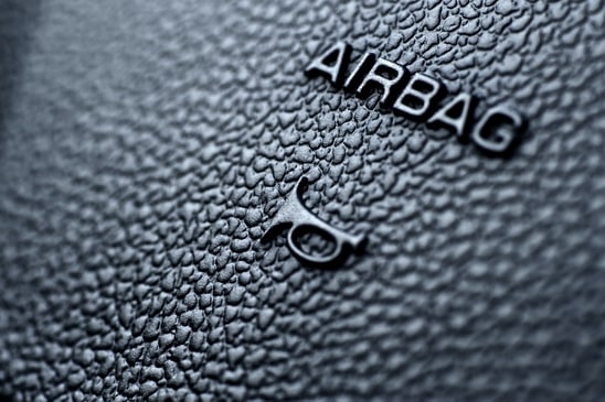 Airbag and Honk Signs on Modern Vehicle Steering Wheel. Macro Shot