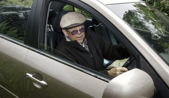 A very old man with a valid driving license drives his car.