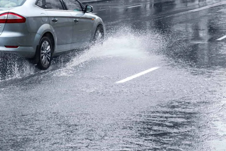 Car driving on huge puddle during a downpour